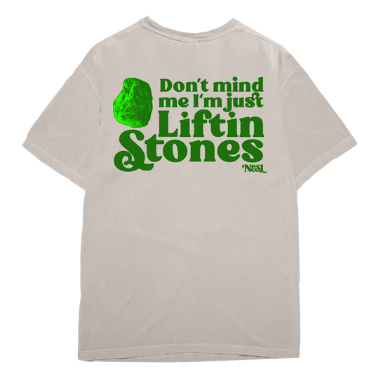 Beige t-shirt with green text 'Don't mind me I'm just Liftin Stones' on a white background